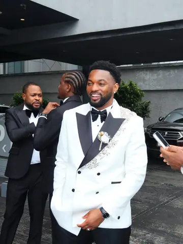 A groom in a white dinner jacket with his groomsmen